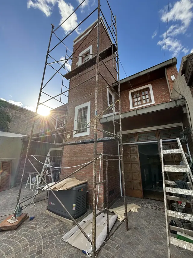 Obra en altura sobre el frente de una casa de ladrillo