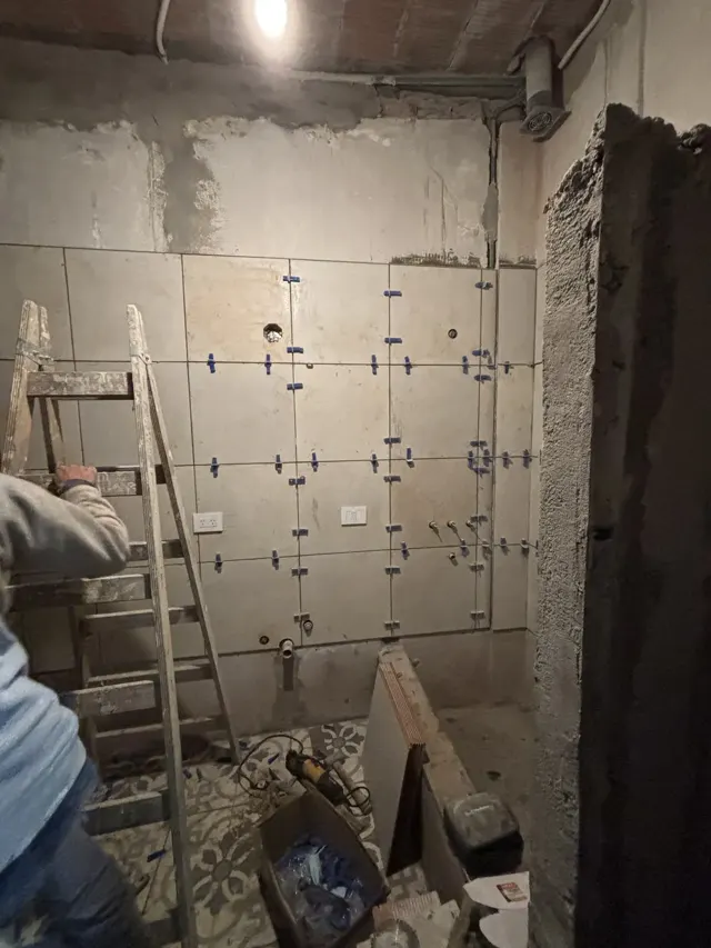 Colocación de porcelanato en la pared de un baño